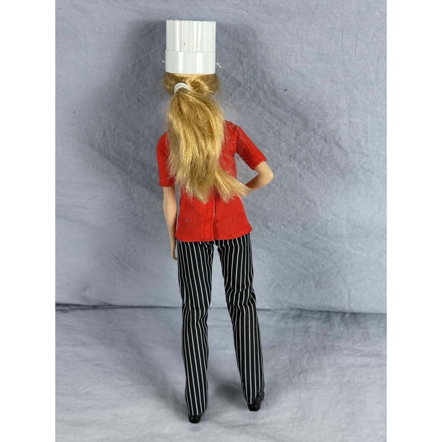 Barbie Chef Doll Mattel Careers Red Jacket Striped Pants Chef Hat Shoes Blonde viewed from behind, showcasing hairstyle and outfit.
