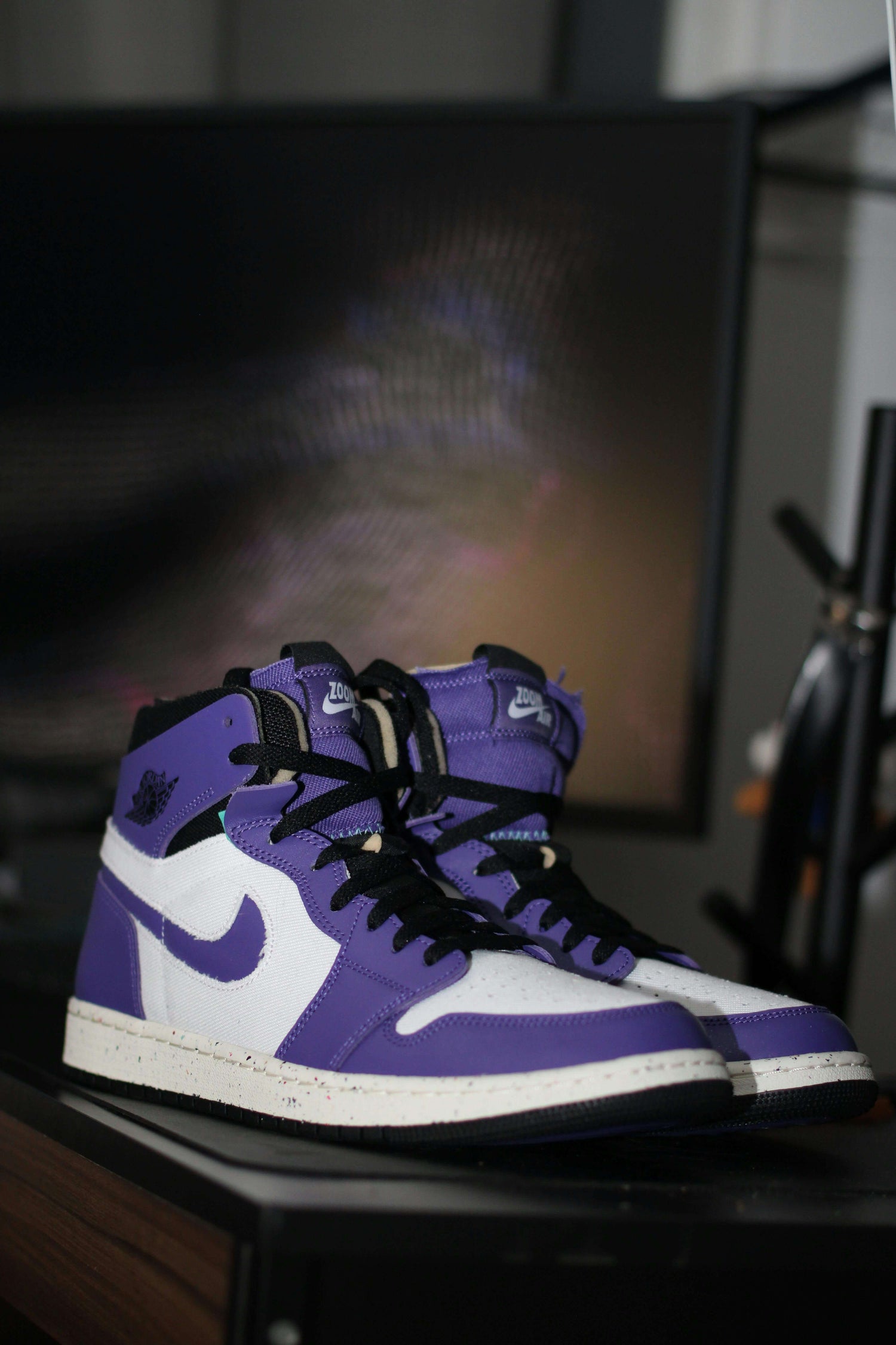 Stylish purple and white high-top sneakers, showcasing trendy Shoes on a wooden surface.