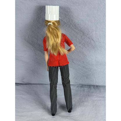 Barbie Chef Doll Mattel Careers Red Jacket Striped Pants Chef Hat Shoes Blonde viewed from behind, showcasing hairstyle and outfit.